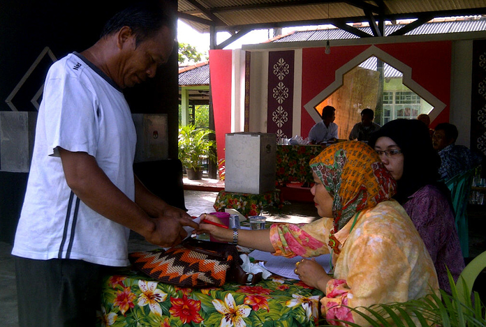 warga-menyerahkan-undangan-memilih-di-tps-02-sungaibaru-muntok_20151209_081310.jpg