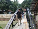 Warga-terlihat-melintas-di-atas-jembatan-besi-di-Jepara.jpg