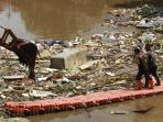 alat-berat-mengangkat-sampah-pasca-banjir-di-kali-sunter_20210222_185242.jpg
