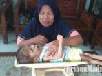asmiatun-menimbang-berat-badan-fajar-di-ruang-tamu-rumahnya-di-mojokerto.jpg