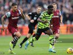 bukayo-saka-kanan-menghindari-kejaran-bek-west-ham.jpg
