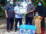 dedi-berfoto-bersama-dengan-keluarga-m-ridho-sambil-menerima-bingkisan.jpg