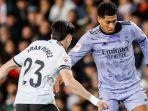 jude-bellingham-real-madrid-saat-dihadang-pemain-valencia-di-liga-spanyol-2023-2024.jpg