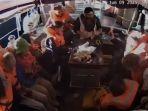 kru-kapal-Madleen-duduk-dengan-tangan-terangkat-sambil-mengenakan-jaket-pelampung.jpg