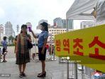 memeriksa-suhu-tubuh-penumpang-korea-utara.jpg