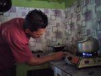 menyalakan-kompor-yang-menggunakan-biogas-di-rumahnya2.jpg