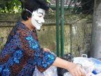 nani-sugiarti-memakai-topeng-saat-melayani-konsumen-yang-membeli-bubur.jpg