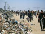 orang-orang-berjalan-di-jalan-yang-dipenuhi-sampah-di-khan-yunis-di-jalur-gaza-selatan.jpg