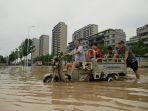 orang-orang-mengarungi-jalan-yang-banjir-china.jpg