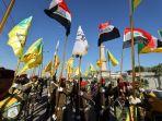 pejuang-mengibarkan-bendera-irak-dan-al-nujaba-dan-kataib-hezbollah.jpg