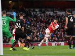 pemain-arsenal-sokratis-menengan-bola-ke-gawang.jpg