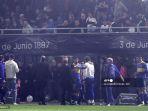 pemain-boca-juniors-terlihat-di-sisi-lapangan-setelah-polisi-melemparkan-gas-air-mata.jpg
