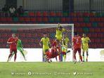 pemain-malaysia-jersey-kuning-dan-laos-berduel-memperebutkan-bola.jpg