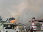 pengendara-melintasi-kantor-bupati-jayawijaya-yang-terbakar-saat-aksi-unjuk-rasa-di-wamena.jpg