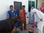 peserta-kurban-memandikan-sapi-sebelum-disembelih-di-masjid-nurul-huda-padang.jpg