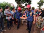 petugas-damkar-membawa-ibu-dari-bocah-yang-tenggelam-di-kali-pesanggrahan.jpg