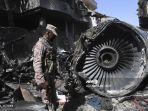 petugas-keamanan-berdiri-di-samping-puing-puing-pesawat-pakistan-international-airlines.jpg