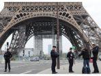 petugas-polisi-memeriksa-dokumen-seorang-pria-di-depan-menara-eiffel-di-paris.jpg