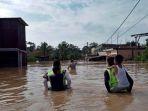 polisi-bantu-anak-anak-lewati-banjir.jpg