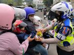 polwan-beri-bingkisan-pengendara-bawa-anak-pakai-helm_20211002_183845.jpg