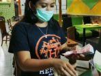 pratisia-kurniawati-sedang-memasukkan-uang-rp-1-juta-ke-dalam-nasi-bungkus.jpg