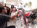 putu-bonus-sudiana-mencoba-tantangan-baru-melukis-dengan-bodi-motor-trail-listrik.jpg