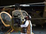 seorang-anggota-taliban-berdiri-di-samping-helikopter-yang-rusak.jpg