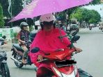 seorang-ibu-mengendarai-sepeda-motor-yang-telah-dilengkapi-payung_20170307_223348.jpg