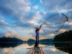 seorang-nelayan-sedang-melempar-jaring-ikan-di-danau-situ-gede.jpg
