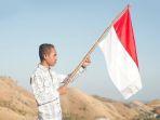 seorang-pemuda-mengibarkan-bendera-merah-putih-di-labuan-bajo-shutterstock.jpg