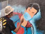 seorang-peserta-lomba-mural-tengah-melukiskan-tokoh-superhero-bermasker.jpg