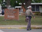 seorang-petugas-berjalan-di-luar-sekolah-dasar-robb-di-uvalde-texas-pada-24-mei-2022.jpg