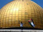 seorang-warga-mengibarkan-bendera-perjuangan-palestina-di-kompleks-masjid-al-aqsa.jpg