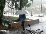 seorang-warga-saat-berjalan-ketika-hujan-mengguyur-kota-padang45.jpg