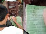 siswa-lelaki-mencatat-pelajaran-di-atas-daun-pisang.jpg