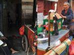 slamet-parmin-hadiwiyono-78-sedang-melihat-gerobak-dagangannya.jpg