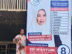 sri-wahyuni-berfoto-di-spanduk-lapak-ikan-miliknya.jpg