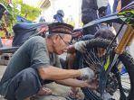 suryadi-yang-membantu-memasang-ban-dalam-roda-depan-motor.jpg