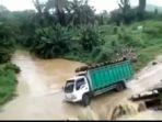truk-pengangkut-kelapa-sawit-terguling-ke-sungai-banjir-deras-sopir-masih-dalam-kabin.jpg