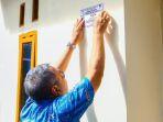 wali-kota-tangerang-selatan-benyamin-davnie-memasang-stiker-di-rumah-warga-program-bedah-rumah.jpg