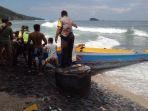 warga-bersama-kepolisian-mengevakuasi-jukung-yang-terbalik-ke-pesisir-pantai.jpg
