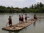 warga-membantu-dua-murid-sekolah-dasar-sd-menyeberangi-derasnya-arus-sungai-buaya_20180324_054102.jpg