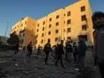 warga-palestina-berjalan-di-dekat-gedung-yang-terkena-serangan-udara-israel_20180522_202340.jpg