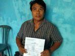 yakob-ndiy-65-saat-memegang-surat-laporan-polisi-atas-kasus-dugaan-persetub.jpg