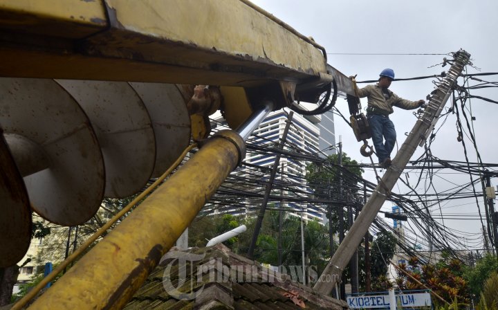 Petugas PLN Membongkar Tiang Listrik Miring