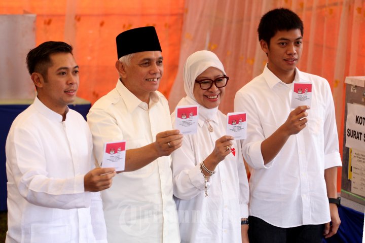 Calon Wakil Presiden Hatta Rajasa ditemani istri Okke, serta kedua putranya Reza dan Rasyid menunjukan surat suara setelah menggunakan hak pilihnya di TPS 01 Kampung I, Desa Jejawi, Kecamatan Jejawi, Ogan Komering Ilir, Sumatera Selatan, Rabu (9/7/2014).Pasangan nomor urut 1 mengungguli suara di tempat pencoblos Cawapres H Hatta Rajasa. Nomor urut 1 meraih suara 494 dari mata pilih 595. Sementara pasangan nomor urut 2 mendapat 12 suara.