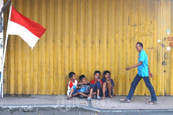 Anak-anak Asyik Bermain Ponsel di Trotoar