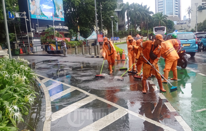 Anggota PPSU Mengeringkan Genangan Air Hujan