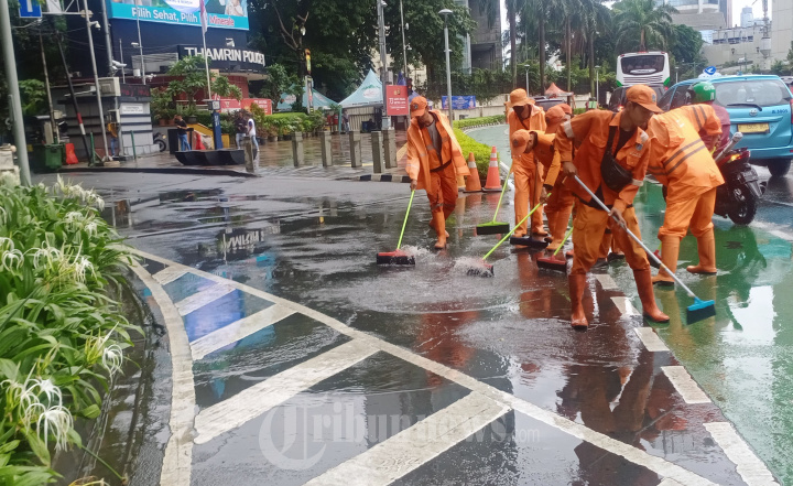 Anggota PPSU Mengeringkan Genangan Air Hujan