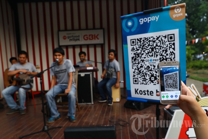 Pengunjung GoFood Festival memberikan apresiasi kepada Koste band, musisi jalanan binaan Institut Musik Jalanan (IMJ) menggunakan GoPay di area Gelora Bung Karno, Jakarta, Sabtu (17/8/2019). 